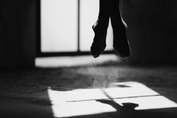 A ballerina jumping on a dusty floor